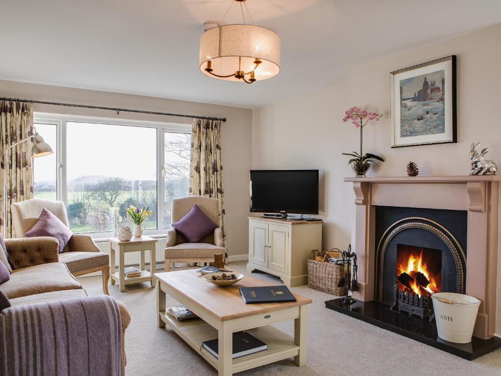 a living room with a fireplace and a tv at Lodge Farmhouse in Scarborough