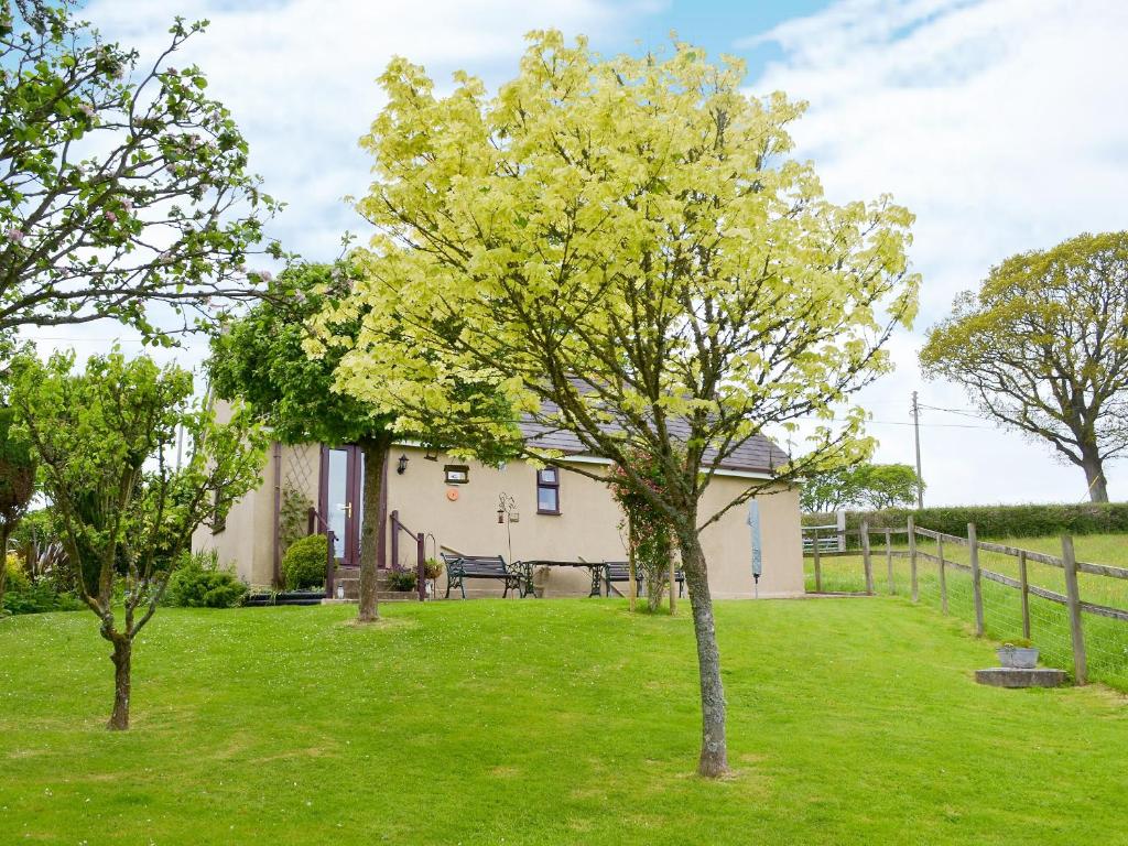 ein Haus mit Bäumen vor einem Hof in der Unterkunft Oakwood Venbridge Farm in Cheriton Bishop