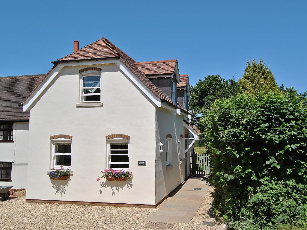 a white house with flower boxes on the windows at Bramble Cottage in Wimborne Minster