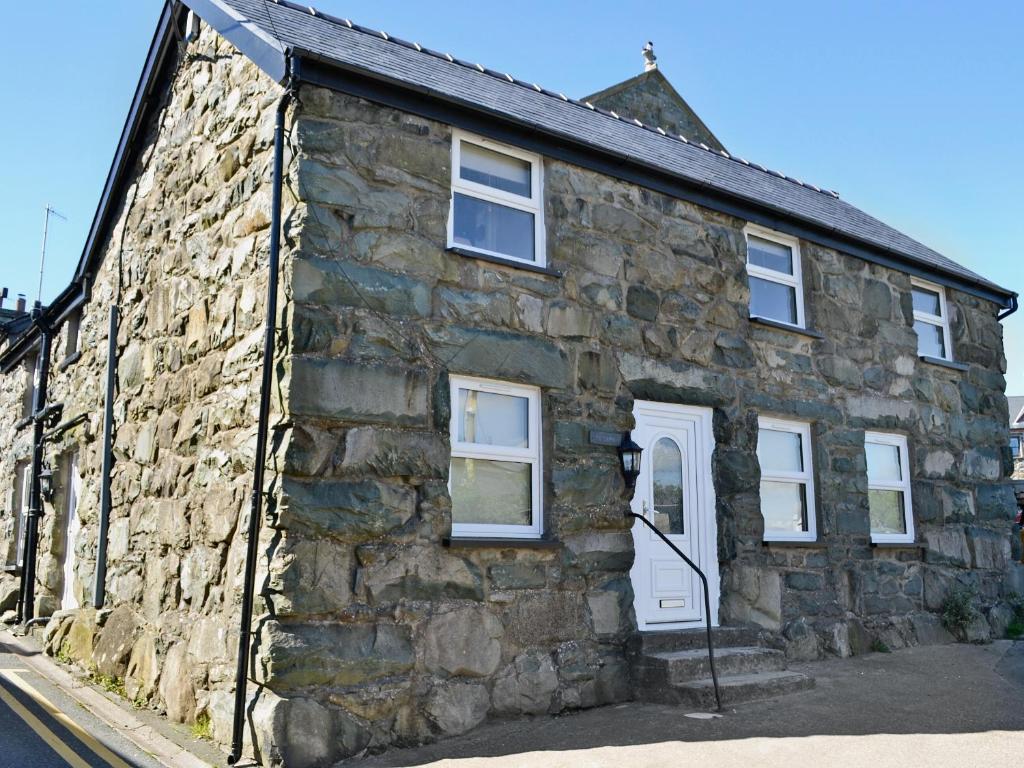 an old stone house on the side of a street at Pendref in Trawsfynydd