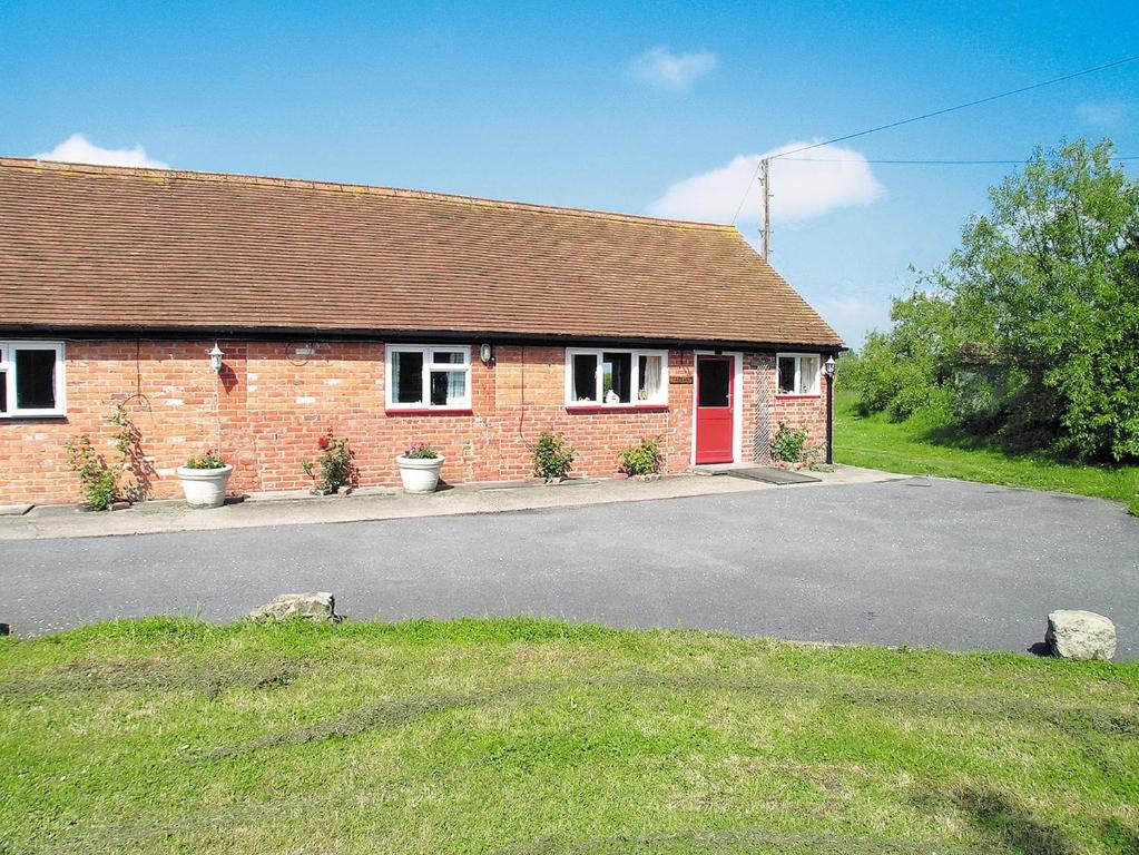 a brick house with a red door on a street at Tarrant Cottage -14557 in West Orchard