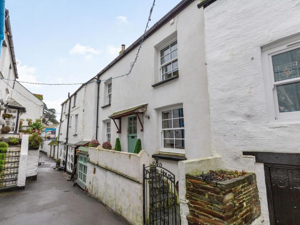 a street with white houses and a fence at Talland House in Polperro