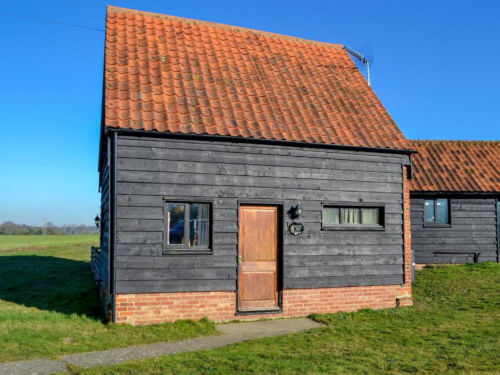 una pequeña casa con techo rojo y puerta en Sallys Nest - E3042 en Blyford