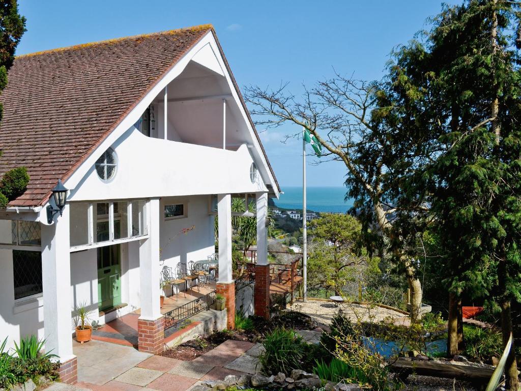 a white house with a view of the ocean at The Garden Flat in Torquay