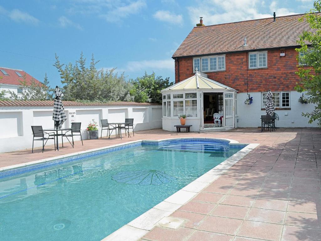 a swimming pool in front of a house at Cockle Warren in South Hayling