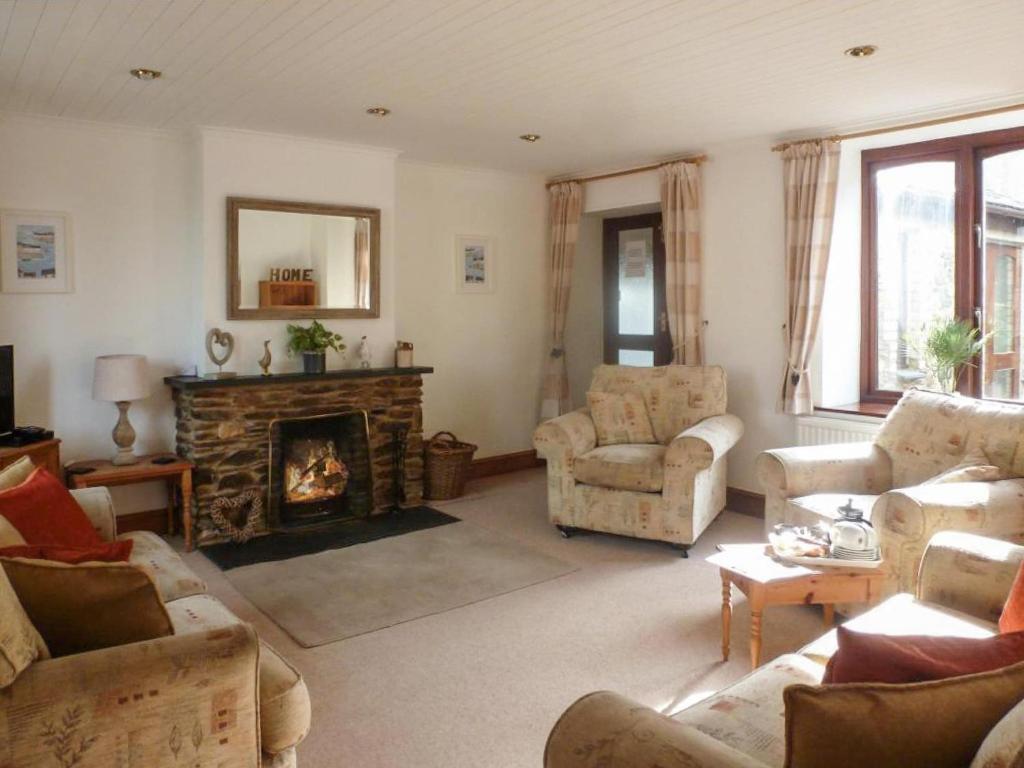 a living room filled with furniture and a fireplace at Penty Rosen in Pentewan