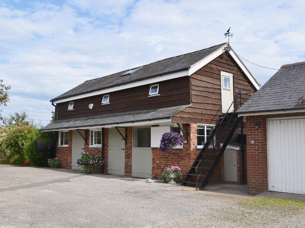 a red brick house with a garage at Broadoak Barn in Ellesmere