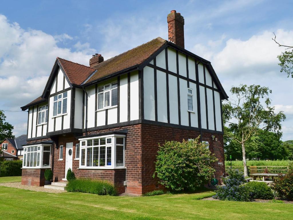 a brick house with black and white windows at Tudor House in Eastrington