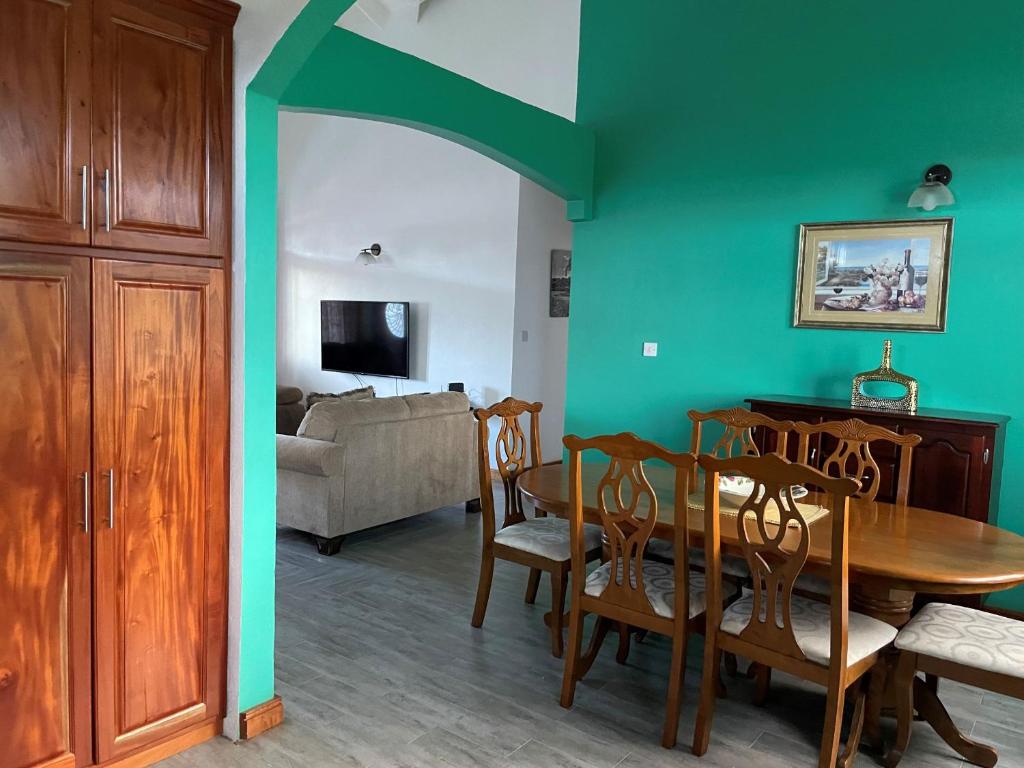 ein Esszimmer mit einem Tisch und einem Sofa in der Unterkunft Travellers Villa in Roseau