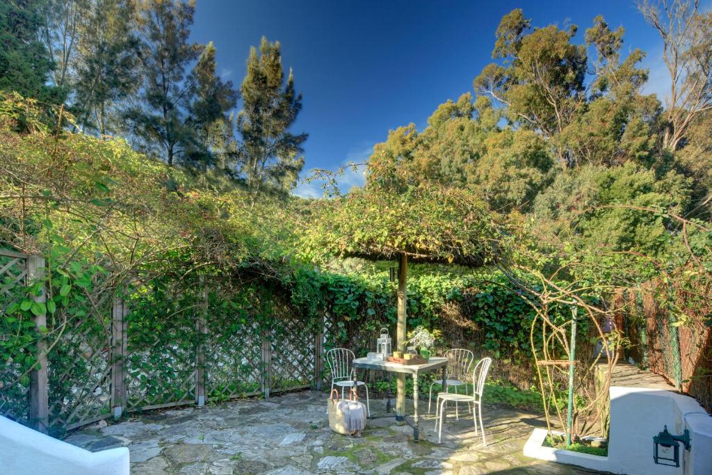 a patio with a table and chairs under an umbrella at Cortijo La Hoya in El Bujeo