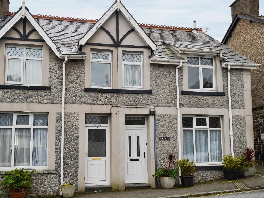 a brick house with white doors and windows at Wendon in Criccieth