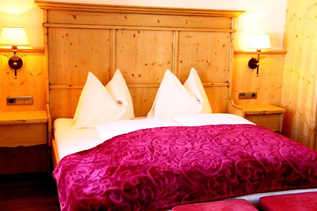 Un dormitorio con una gran cama roja con almohadas blancas en Ferienhaus Klocker en Ried im Zillertal