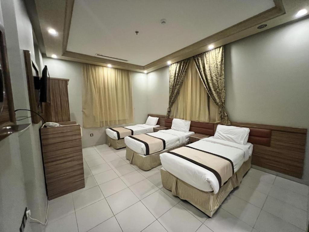 a hotel room with two beds and a television at اوتاد الششة in Makkah