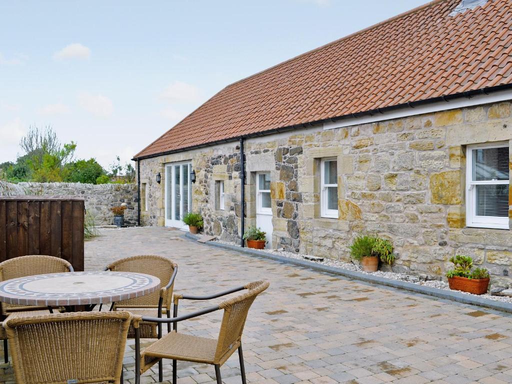 a patio with a table and chairs and a building at Castle Dairy - 27901 in Ceres