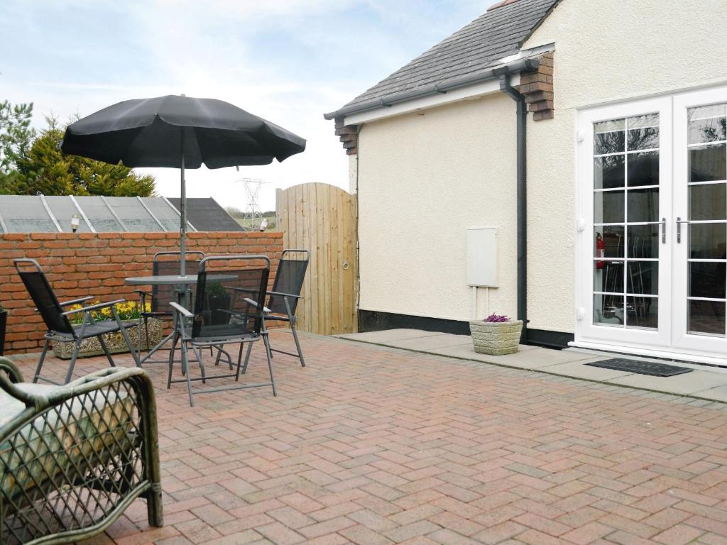 a patio with a table and an umbrella at The Snug in Valley