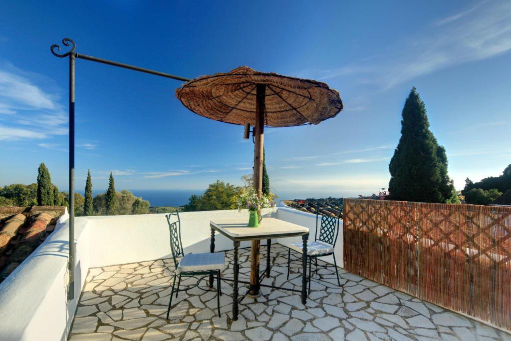 a table with two chairs and an umbrella on a patio at Cortijo La Hoya in El Bujeo