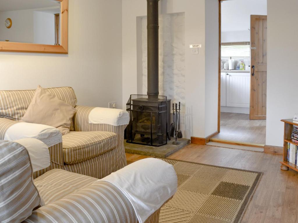 a living room with two couches and a wood stove at Hay Loft -23894 in Aylmerton