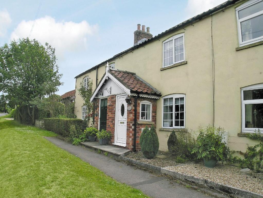 a brick house with a white door and a yard at No 2 Flowery Bank in Malton