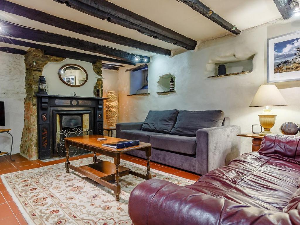 a living room with a couch and a fireplace at Laity in Polperro