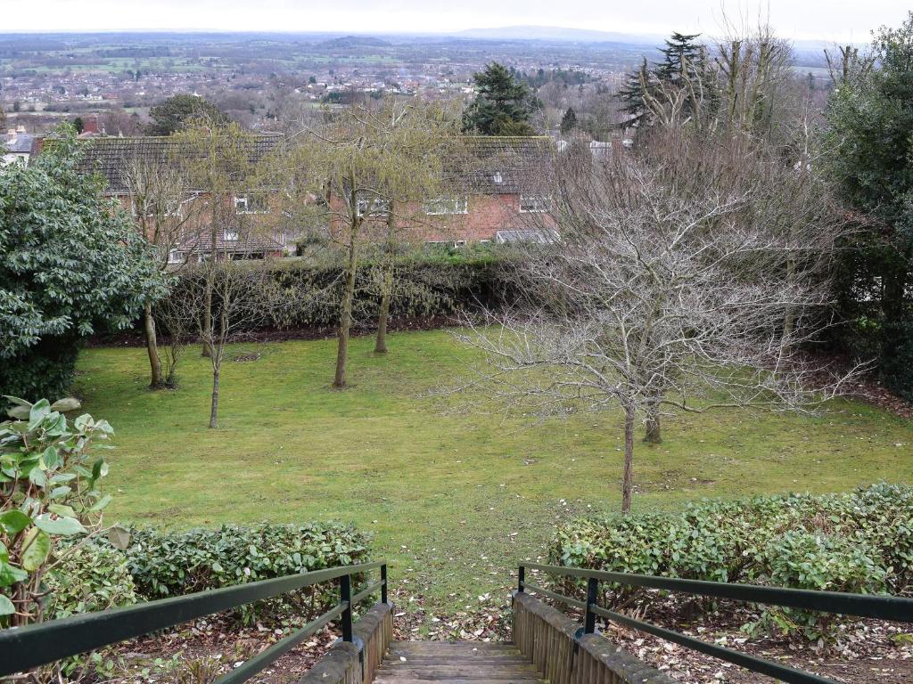 a view of a park with a wooden path and trees at Valeview Cottage in Great Malvern