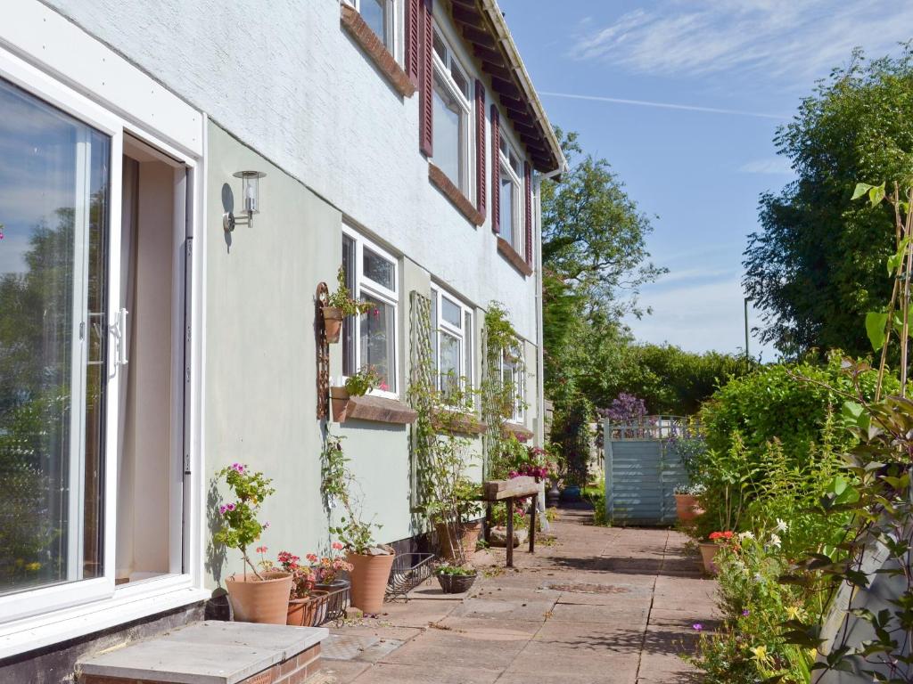 a house with potted plants on the side of it at Garden View in Brixham