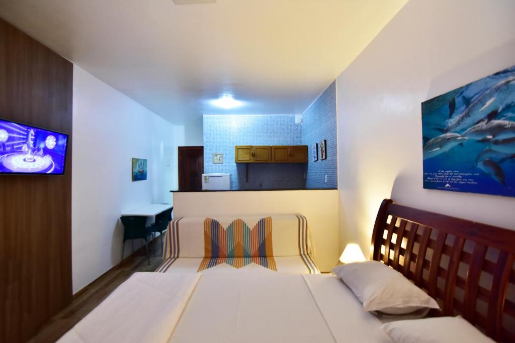 Habitación pequeña con cama y cocina en Estalagem 11 Suites, en Arraial do Cabo