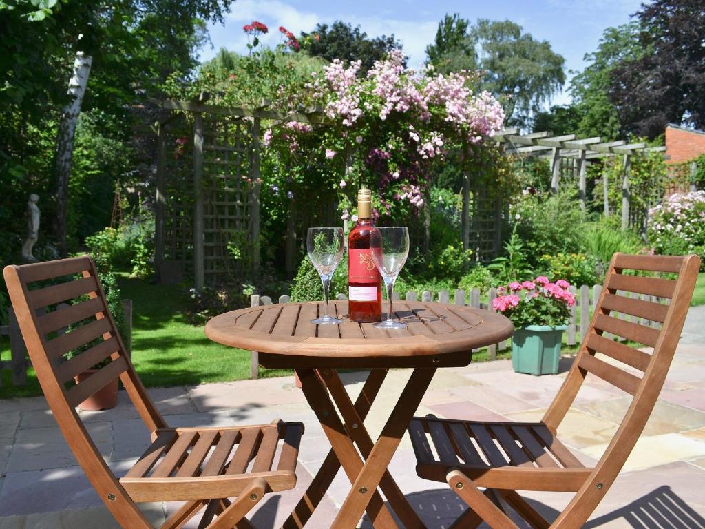 een tafel met een fles wijn en twee stoelen bij The Old Forge in Saxilby