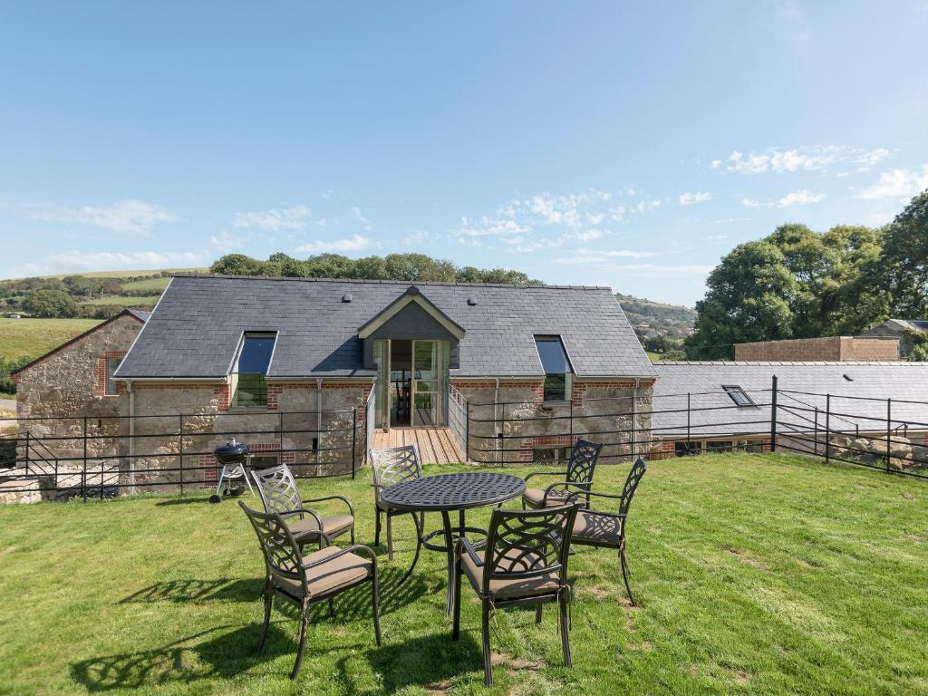 a table and chairs in front of a house at Property 1 in Wroxall