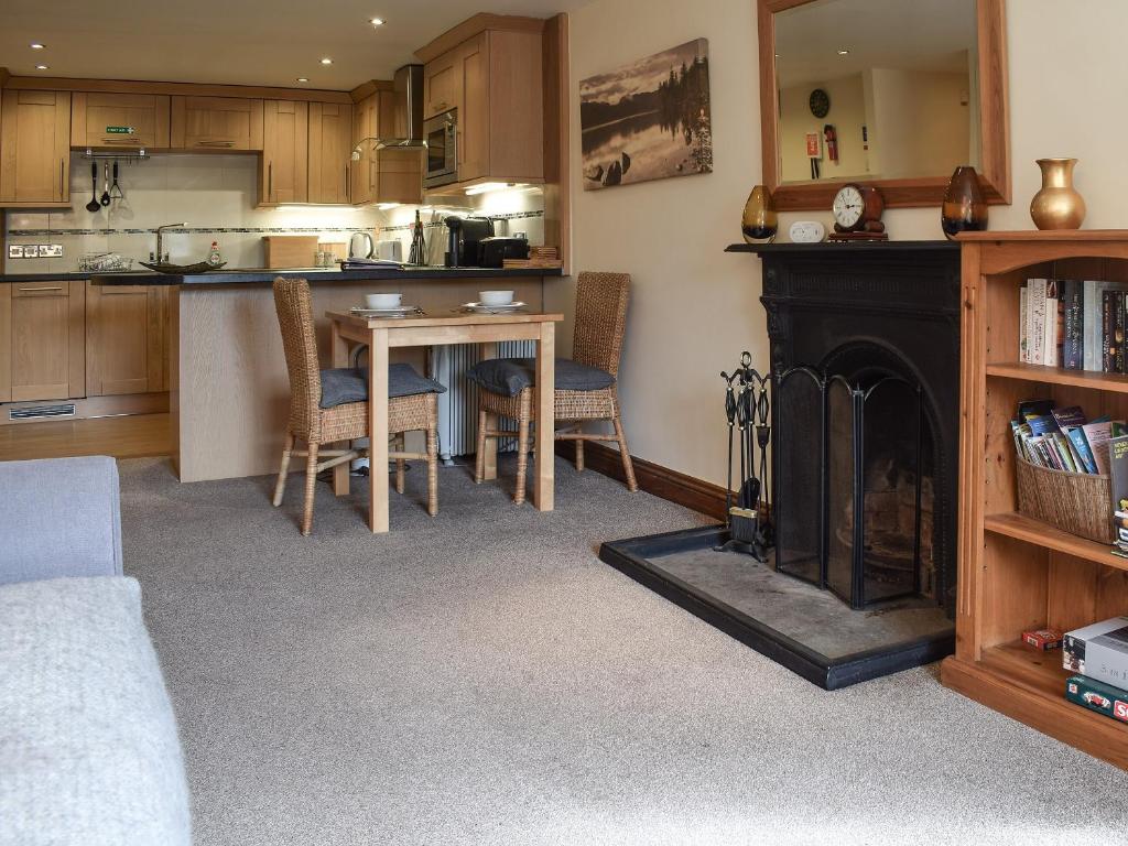 a kitchen and dining room with a table and a fireplace at Church View in Ambleside