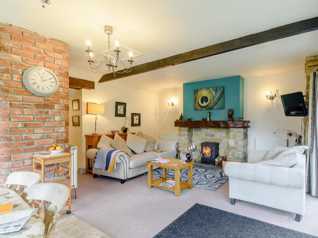 uma sala de estar com um sofá e uma lareira em The Forge em Hawnby