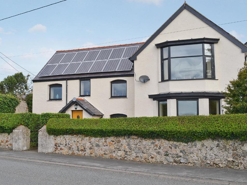 a house with solar panels on the roof at Pen Yr Allt in Rhosneigr