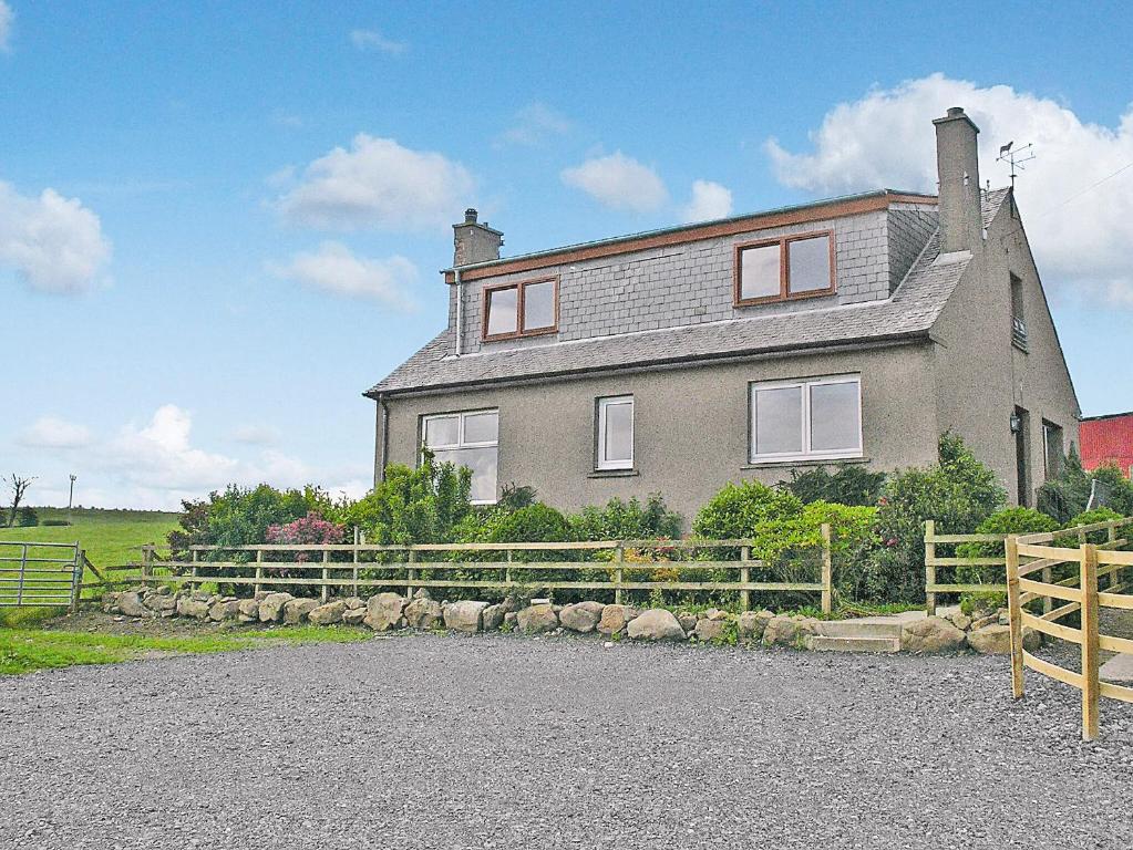 a large house with a fence in front of it at Bankhead Farm Cottage in Crossgates