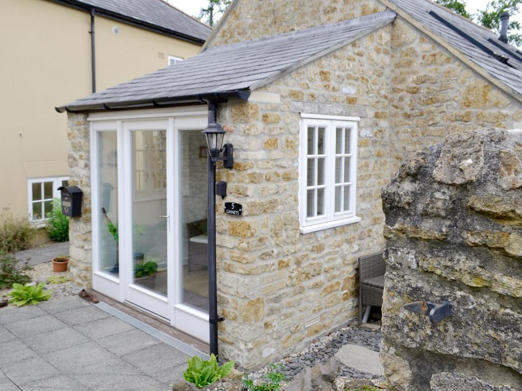 an extension to a stone house with a conservatory at Linnets in Beaminster