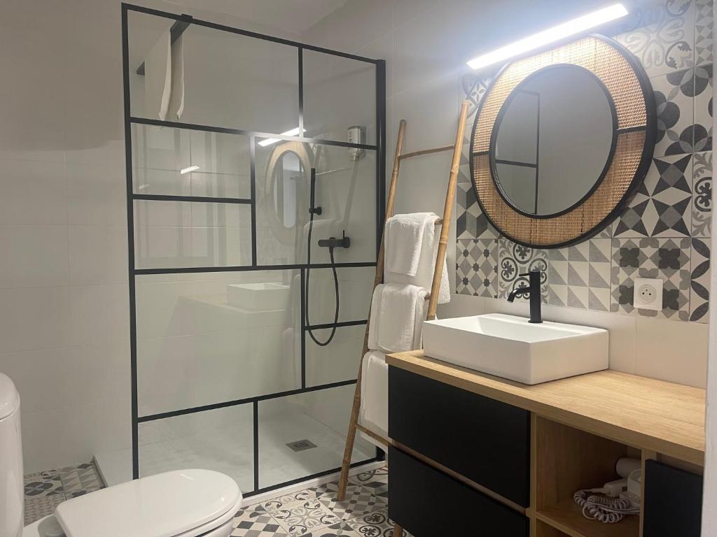 a bathroom with a sink and a mirror at Hôtel Restaurant La Caravelle in Sari Solenzara