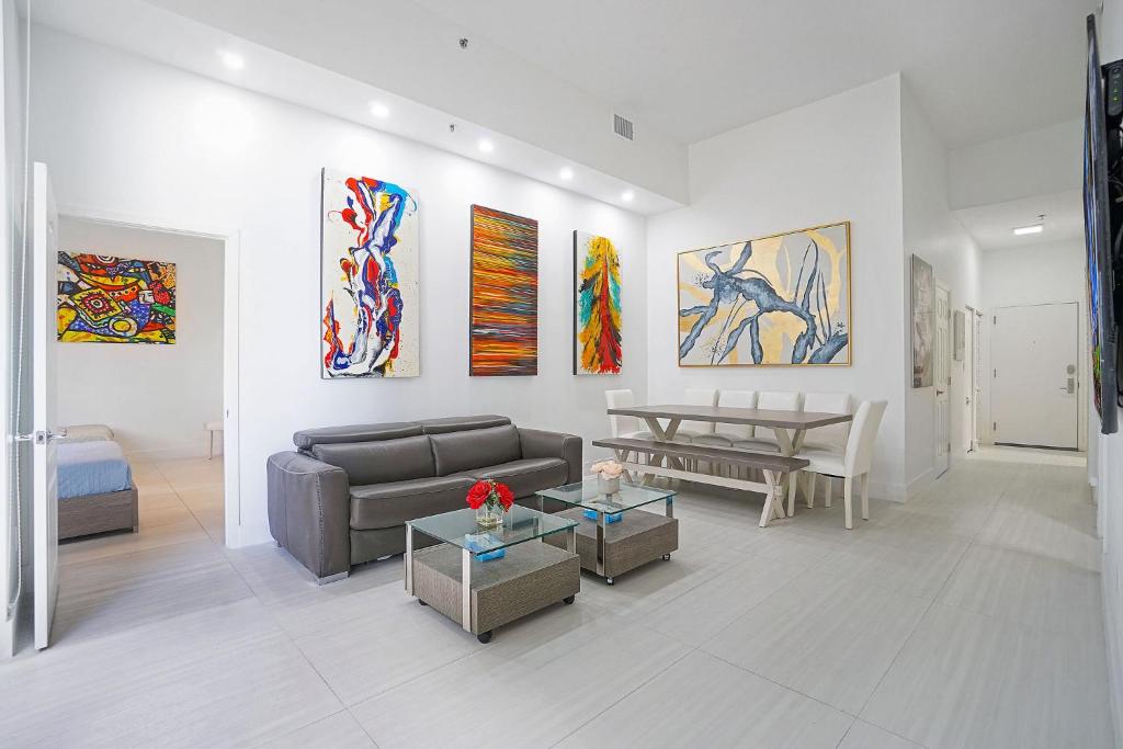 uma sala de estar com um sofá e pinturas na parede em Miami Brickell 4 Bedrooms High Ceiling loft on the pool em Miami