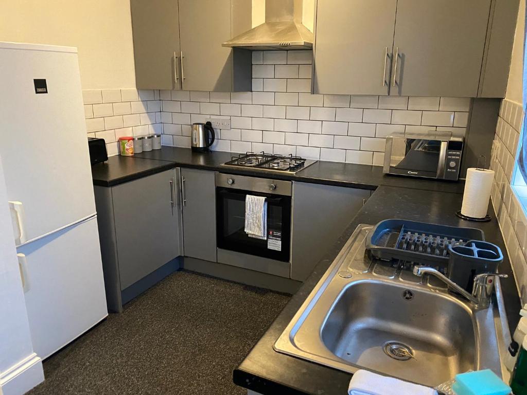 a kitchen with a sink and a stove at Room 2 Peaceful stay Near Derby City Centre in Derby