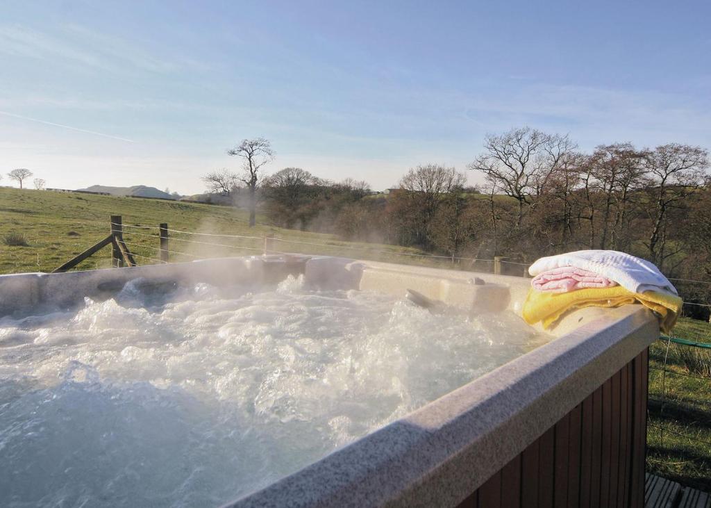 a hot tub with water and a towel in it at Brook View - Hw7477 in Penybont
