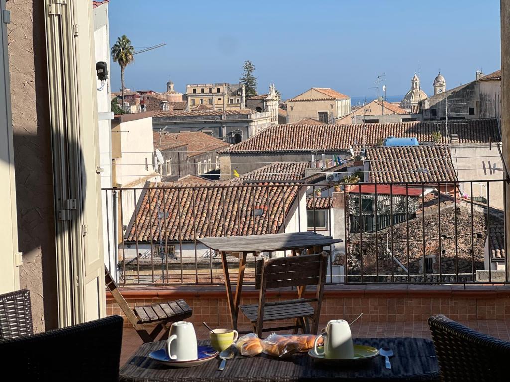 d'une table et de chaises sur un balcon avec vue sur la ville. dans l'établissement Attico Teatro Greco, à Catane