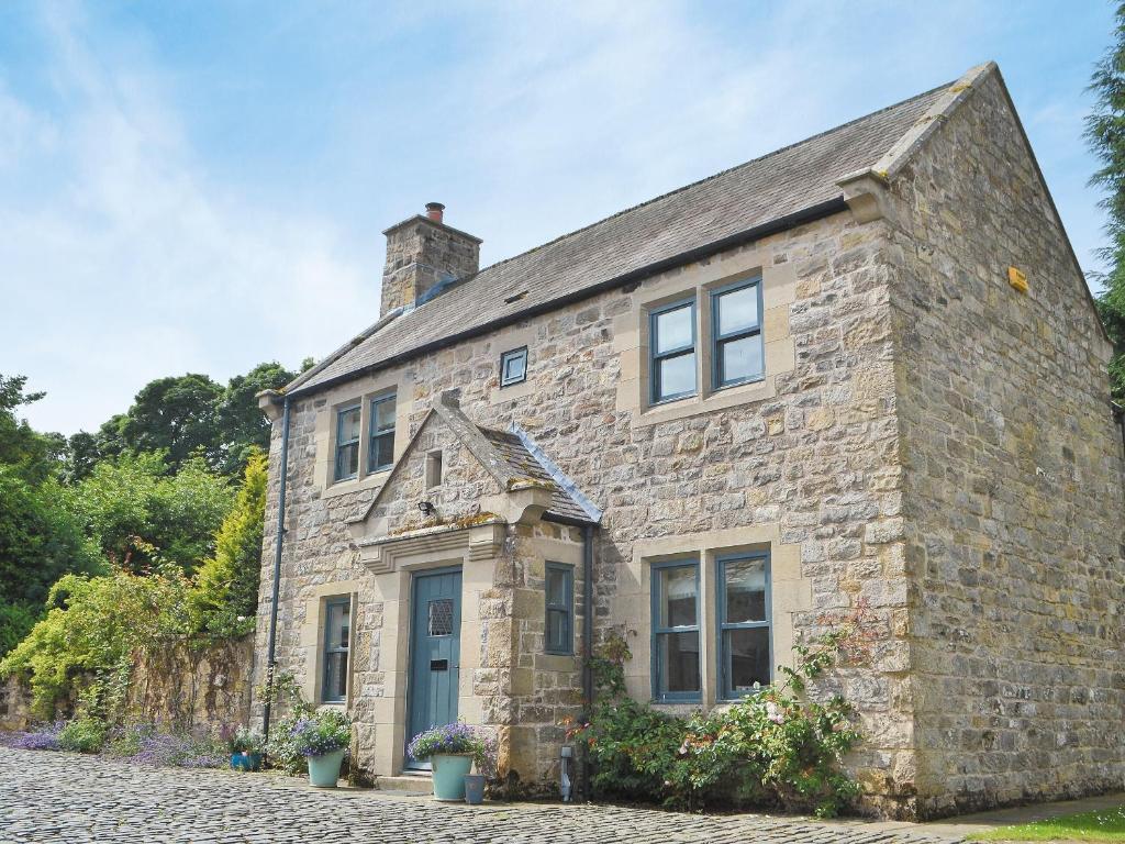 an old stone house with a blue door at Tower Cottage - Mvw in Belsay