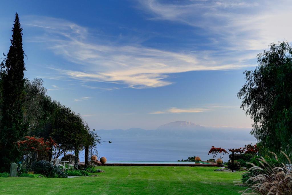 a lawn with a view of the ocean and mountains at Cortijo La Hoya in El Bujeo