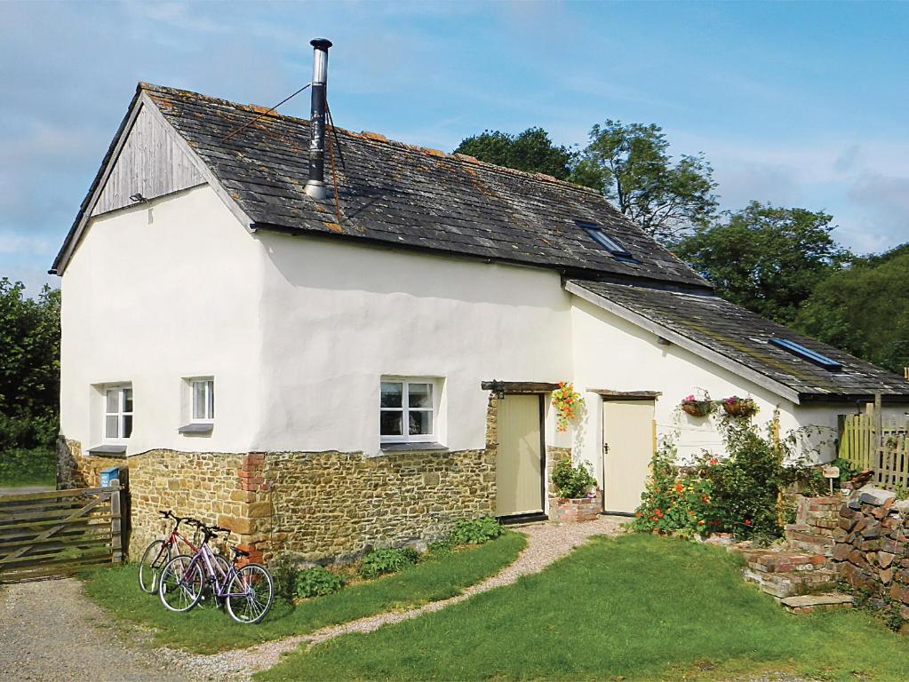 uma casa branca com duas bicicletas estacionadas fora dela em Granny Mcphees Cottage Hssh em Beaworthy