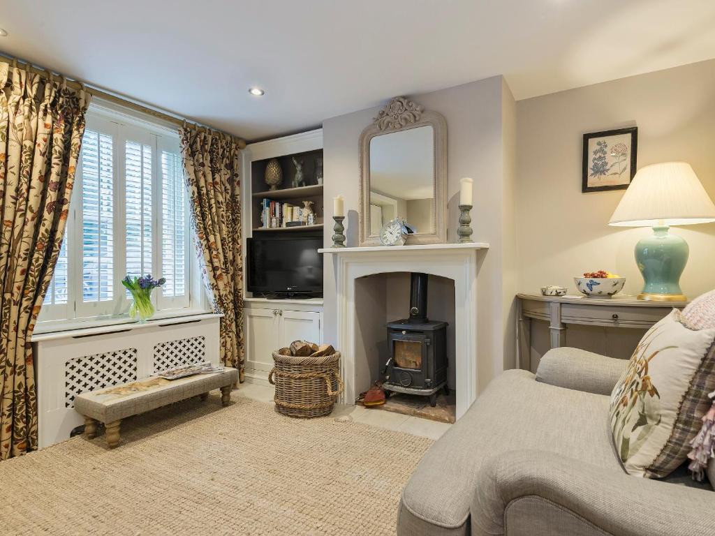 a living room with a fireplace and a mirror at Pear Tree Cottage in Louth