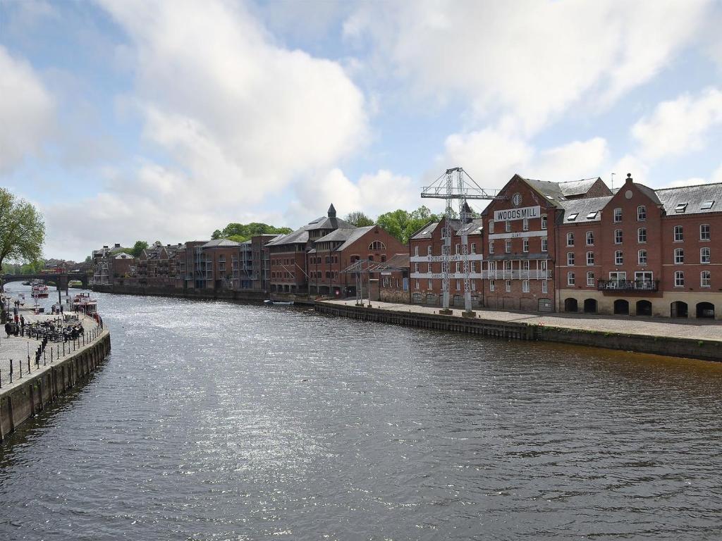 a river in a city with buildings and houses at Jorvik- Woodsmill Quay in York