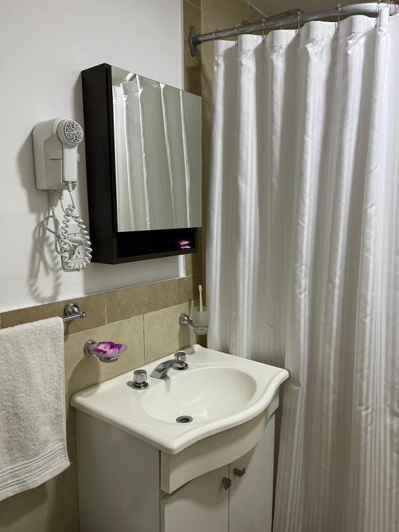 a bathroom with a sink and a shower curtain at Apartamento El Hornero in San Rafael