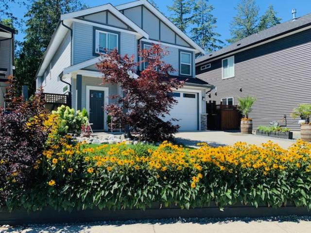 a house with a bunch of flowers in front of it at A Cozy Family get away suite in South Nanaimo in Nanaimo