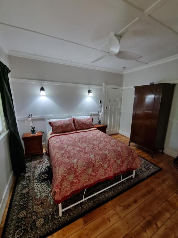 a bedroom with a bed with a red comforter at Shelton-Lea in Katoomba