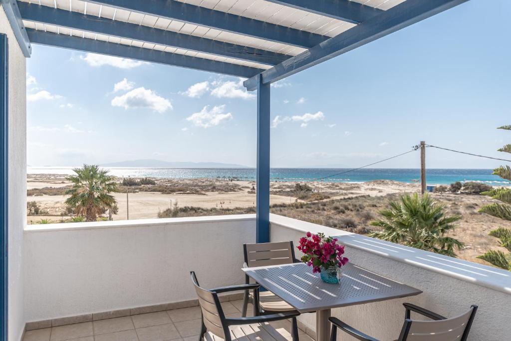 a patio with a table and chairs and a view of the beach at Crystal Naxos 1 Studios at Mikri Vigla in Mikri Vigla