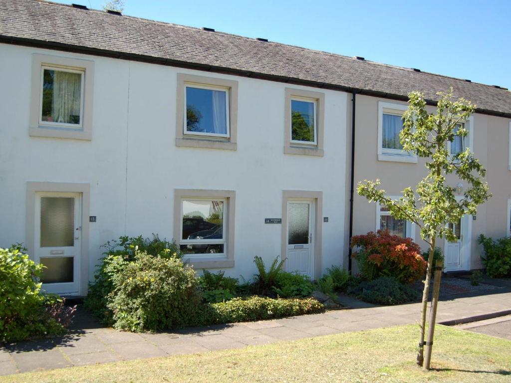 una casa bianca con un albero davanti di Brundholme Glen a Keswick