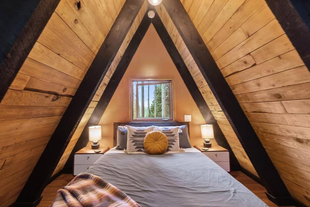 een slaapkamer met een groot bed op zolder bij Epic view A-frame - Hot-tub, Firepit, & Fireplace in Granite Falls