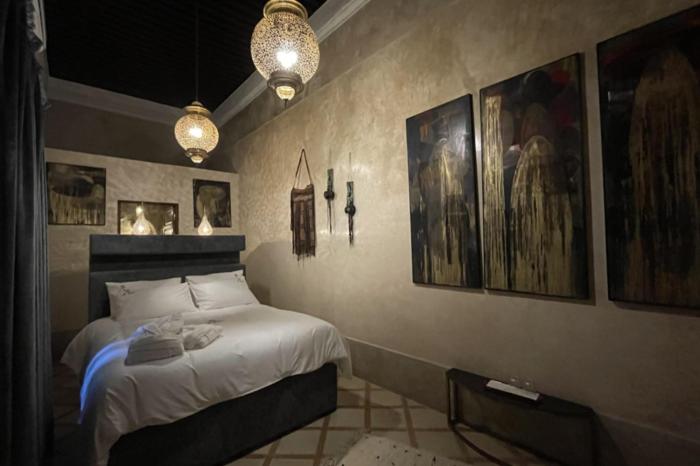 um quarto com uma cama e algumas fotografias na parede em Riad AL Bahi em Rabat